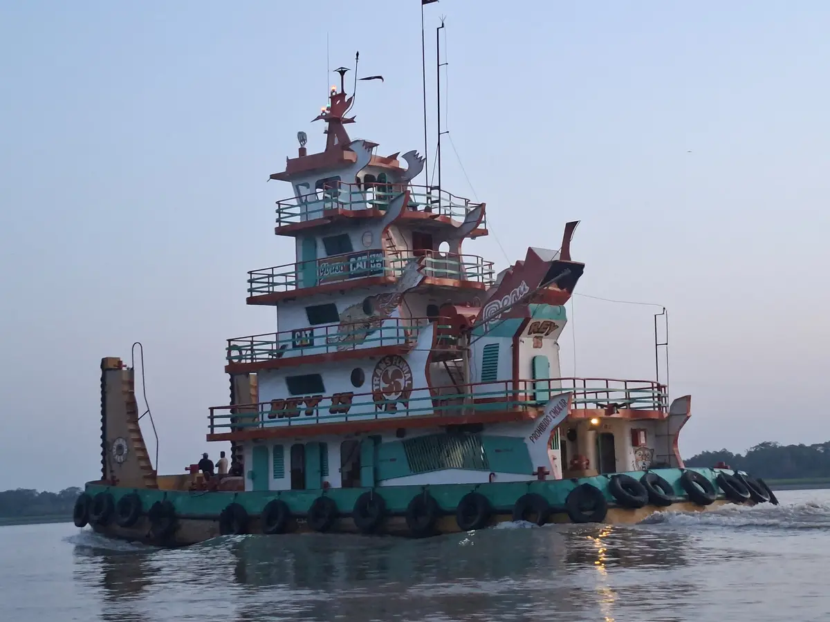 Um rebocador fluvial no Rio Amazonas, com a margem baixa ao fundo